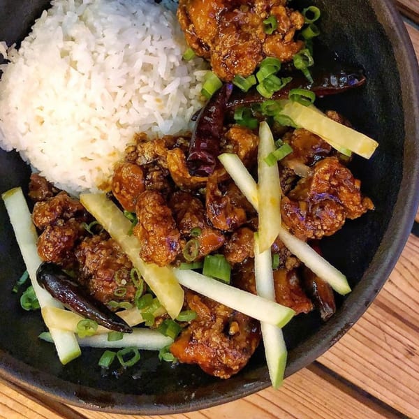 Old Thousand's Chinese dish with crispy chicken, white rice, green onions, and dried chilies.