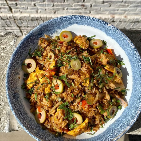 Old Thousand's fried rice with olives, peppers, and herbs in a blue and white bowl.