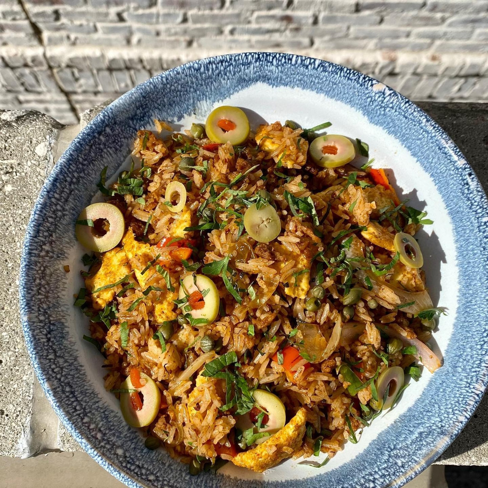 Old Thousand's fried rice with olives, peppers, and herbs in a blue and white bowl.